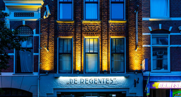 Het gebouw van Theater De Regentes met verlichting in de avond.