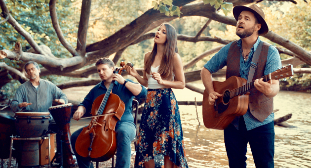 Een groep muzikanten speelt muziek aan de waterkant.