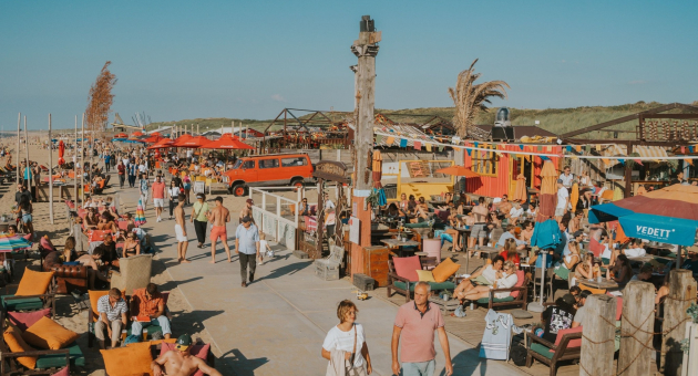 Drukke strandpromenade met mensen, stoelen en Zuid-Afrikaanse sfeer.