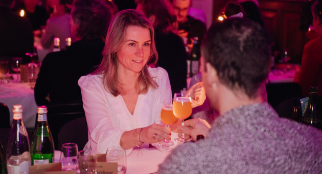 Twee mensen proosten met glazen tijdens een diner.