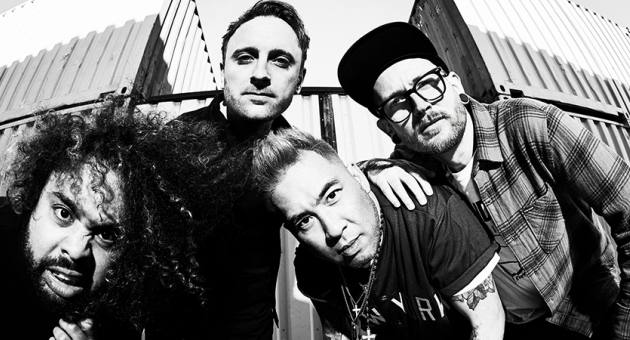 Vier muzikanten van Call it Off poseren voor een containerwand in zwart-wit.