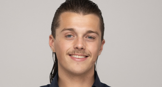 Zanger Chicco lachend met zijn Haagse mat in de camera.