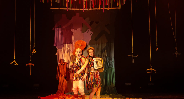 Carnaval van het leven. Twee clowns met instrumenten staan op een kleurrijk podium.