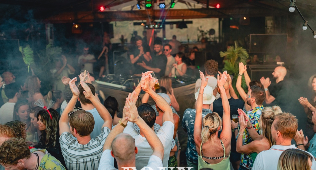 Een groep mensen danst enthousiast in een clubsetting.