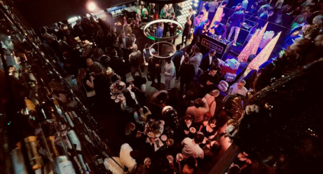 Een drukke menigte op een feest met ronde lichten.