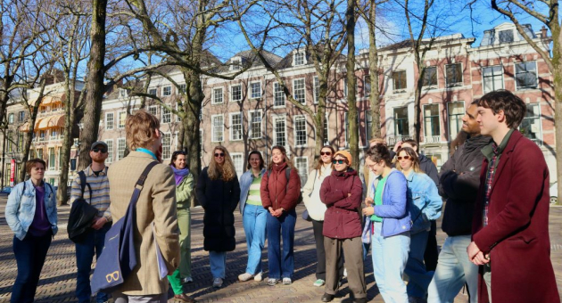 Toeristen luisteren naar een gids in een park.