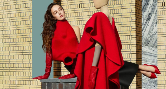 A woman in a red outfit next to a mannequin in similar colors.