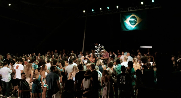 Mensenmassa op een feest met een Braziliaanse vlag op de achtergrond