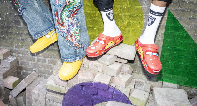 Twee paar kleurrijke schoenen staan op stenen met een muur op de achtergrond.