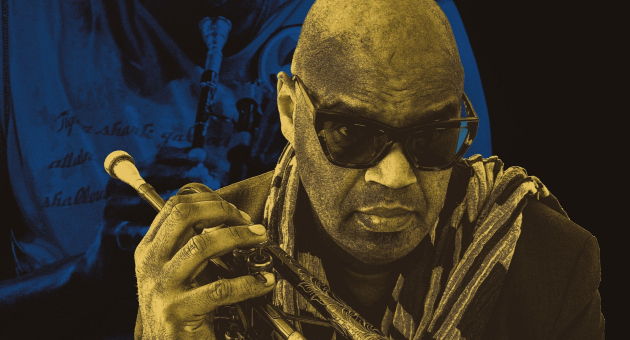 A jazz musician holds a trumpet while wearing sunglasses.