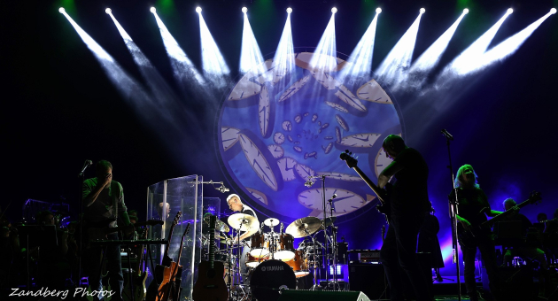 Een band speelt op een podium met felgroen en wit licht.