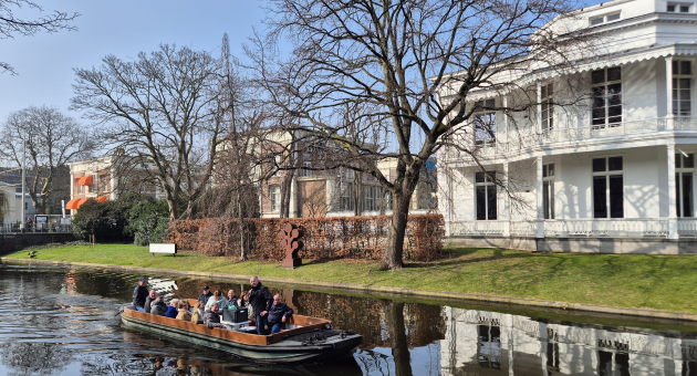 Groep mensen op een boot in een grachtenlandschap