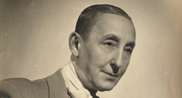 Portret van een elegant geklede persoon in zwart-wit, zittend in een pose met een sigaret in de hand.