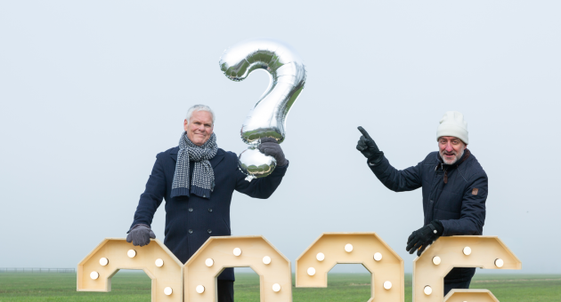 Twee mannen in winterkleding met een groot vraagteken en cijfers.