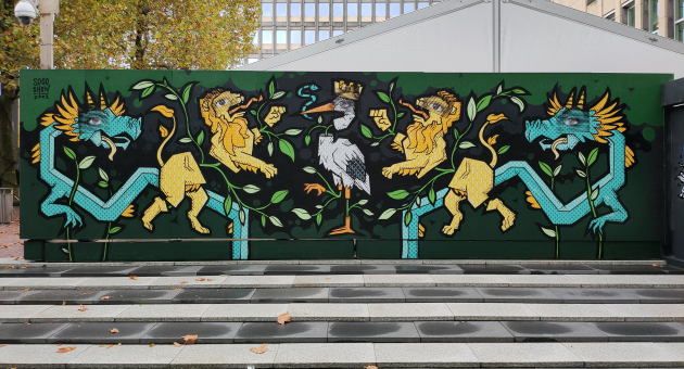 Street art met een ooievaar in het midden en twee gele leeuwen en twee draken ernaast op het Provinciehuis in Den Haag