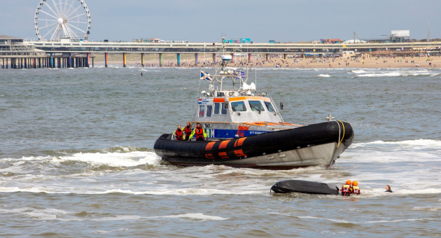 Safe at Sea. Een redboot met bemanning redt mensen in de zee bij Scheveningen.