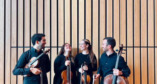 Vier muzikanten met een viool, twee altviolen en een cello, lachend naast elkaar.