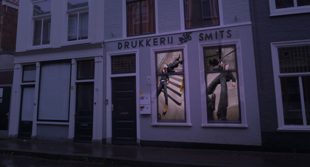 Kunstinstallatie met mannen in windows van drukkerij.