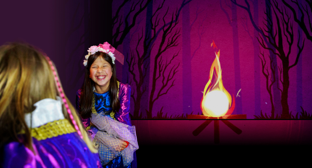 Gelukkig kind in kostuum met bloemen in haar haar bij een vuur.