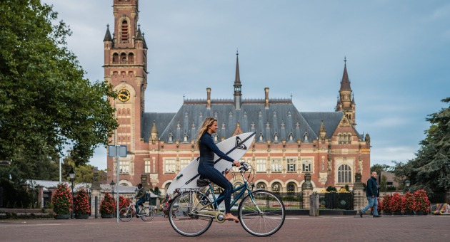 Surfer op de fiets voor het Vredespaleis 