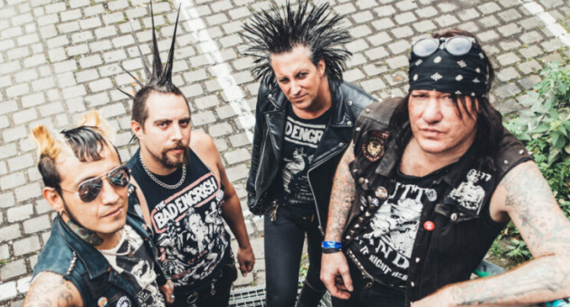 Vier leden van een punkband poseren buiten.
