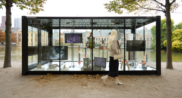 Een vrouw loopt langs een moderne kunstinstallatie bij de Hofvijver.