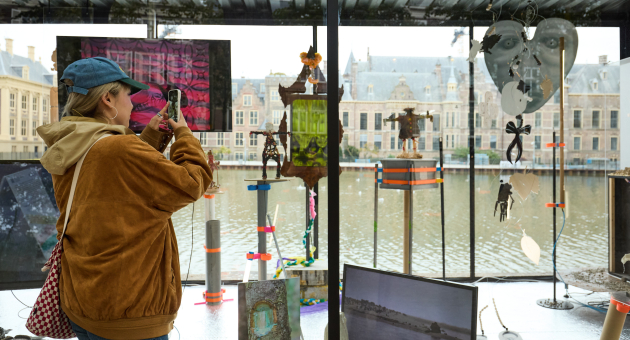 Een bezoeker fotografeert kunstwerken bij de Hofvijver.