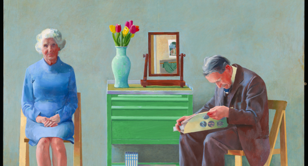 Gemälde einer älteren Frau und eines älteren Mannes, die auf Stühlen neben einem grünen Schränkchen mit Tulpen und einem Spiegel darauf sitzen ©David Hockney