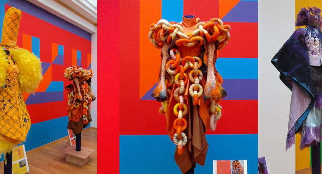 Drie modeontwerpen in felle kleuren op standbeelden.