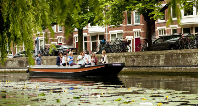 Een sloep vaart in een gracht in Den Haag