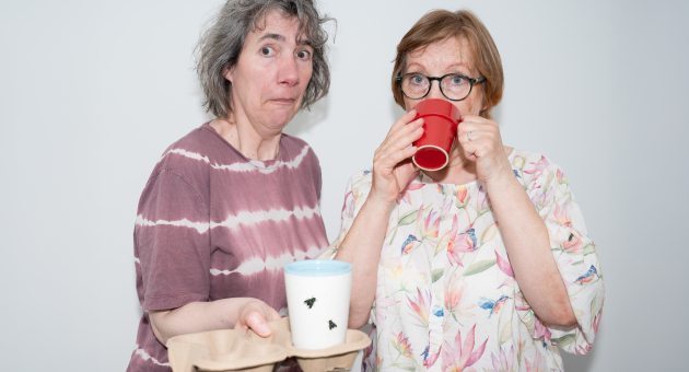 Twee vrouwen met bekers en verbaasde gezichten