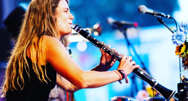 ALBA Theaterhuis Voorleesconcert. Een vrouw met lang haar speelt een klarinet tijdens een optreden.