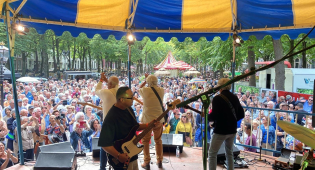 Eine Band spielt vor einer großen Menge in Den Haag.