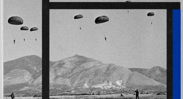 Zwart wit foto van een berglandschap met parachutes in de lucht gemonteerd in een Mondriaan frame met de kleur blauw.