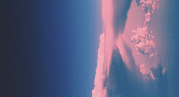 Roze wolken in verticale vorming tegen een diepblauwe lucht