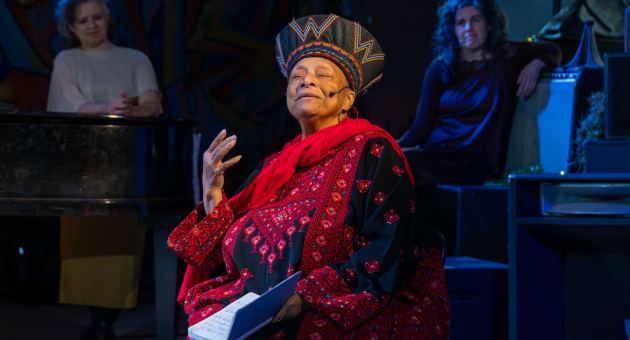 Een vrouw in traditionele klederdracht vertelt een verhaal.