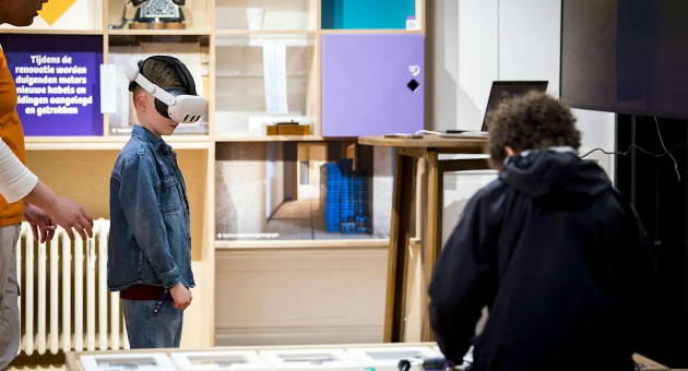 Een kind met een VR-bril, begeleid door een volwassene.
