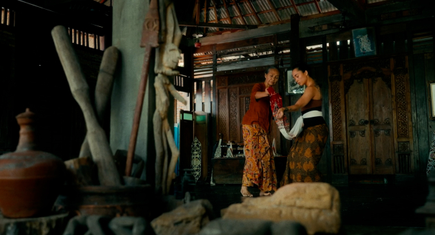 Twee vrouwen in traditionele kleding dansen samen in een binnenruimte.