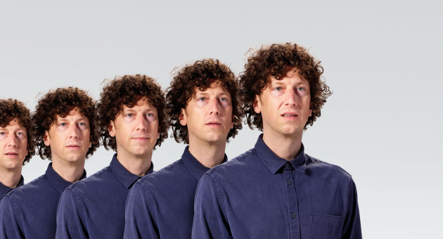 Vijf mannen met krullend haar staan naast elkaar.
