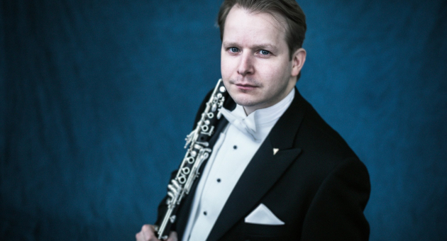 Man in smoking met klarinet, blauwe achtergrond