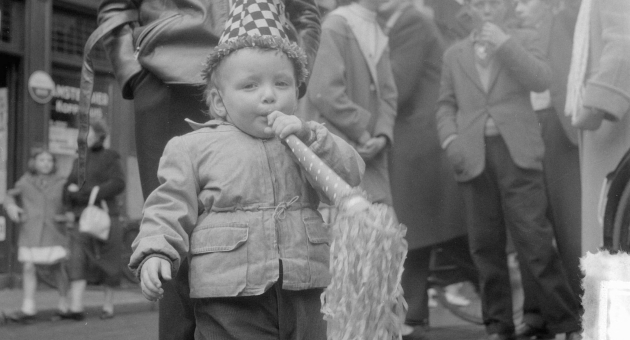 Historische zwart wit foto van een klein jongetje met toeter en feestmuts op op bevrijdingsdag