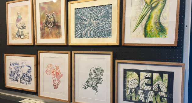 Verschillende kunstwerken aan een muur in Den Haag.