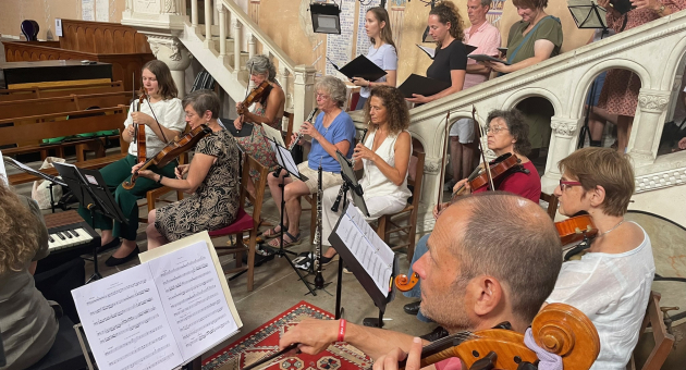 Een groep muzikanten met verschillende instrumenten in een kerk.