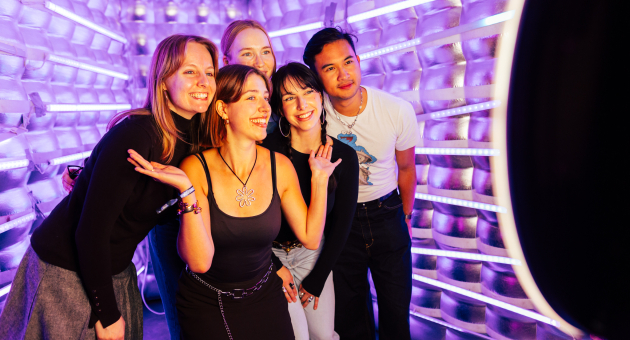 Group of five young people smiling and posing