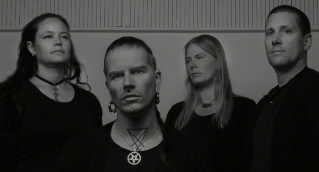 Band Solace in zwarte kleding, serieuze uitdrukkingen.