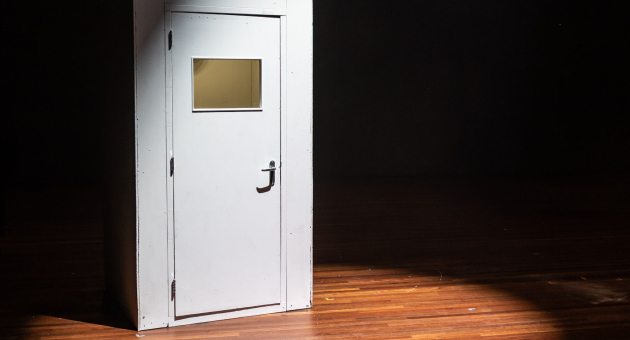 Een dichte deur op een podium in de spotlights. 