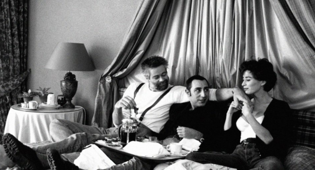 Zwart wit foto van drie mensen zittend in een hemelbed