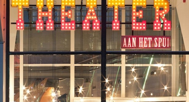 Voorkant van het Theater aan het Spui in het donker met de letters Theater in rood gele lichtjes. 