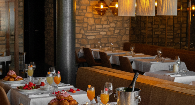 Gedekte tafels in restaurant Lemongrass voor Valentijns brunch. Op de met wit linnen gedekte tafels rozenblaadjes, glazen sap en croissants.