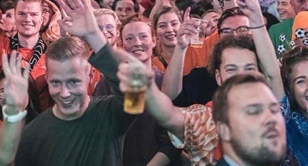 Een grote menigte in oranje kleding die feest viert.